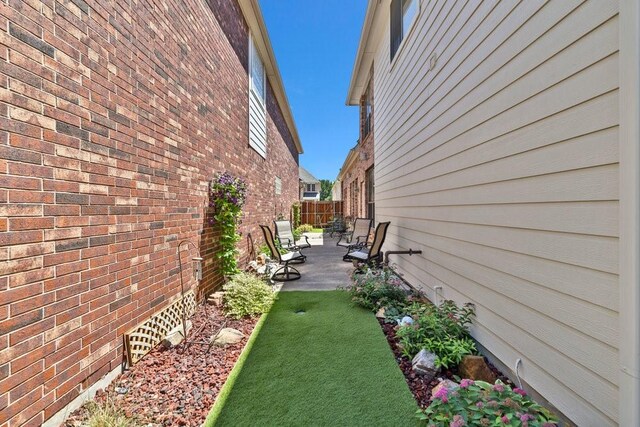 view of side of property with a patio area and fence