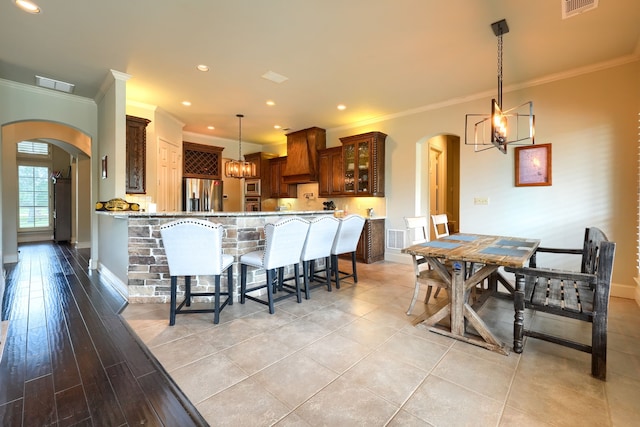 103 Fireside Ct, Mclendon Chisholm, TX 75032 - kitchen featuring stainless steel appliances, arched walkways, ornamental molding, a breakfast bar area, and a chandelier
