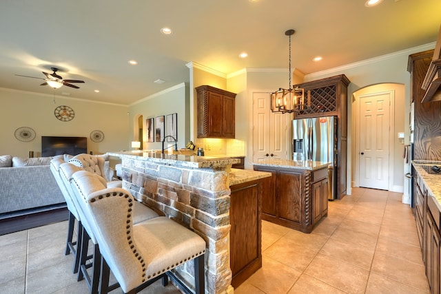 103 Fireside Ct, Mclendon Chisholm, TX 75032 - kitchen featuring arched walkways, open floor plan, light stone counters, stainless steel refrigerator with ice dispenser, and recessed lighting