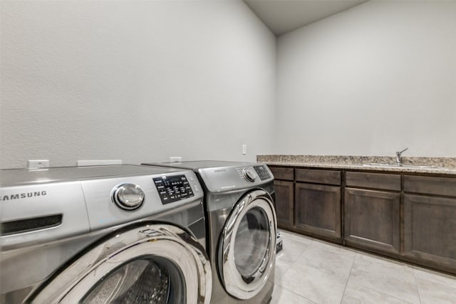 laundry room featuring washer and dryer, light tile patterned floors, and cabinet space