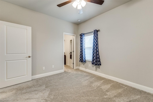 spare room with ceiling fan, carpet, and baseboards
