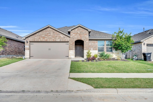 view of front of home featuring brick siding, a front lawn, a garage, and concrete driveway