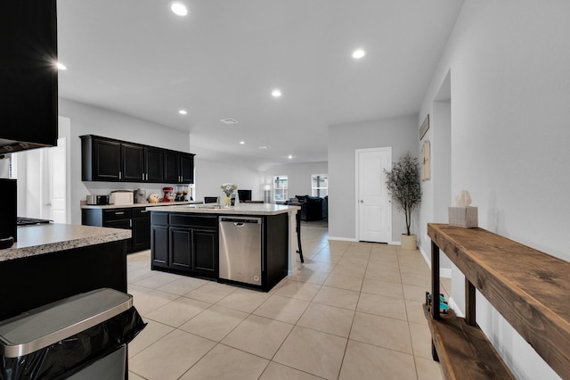 kitchen featuring dark cabinets, dishwasher, light countertops, recessed lighting, and an island with sink