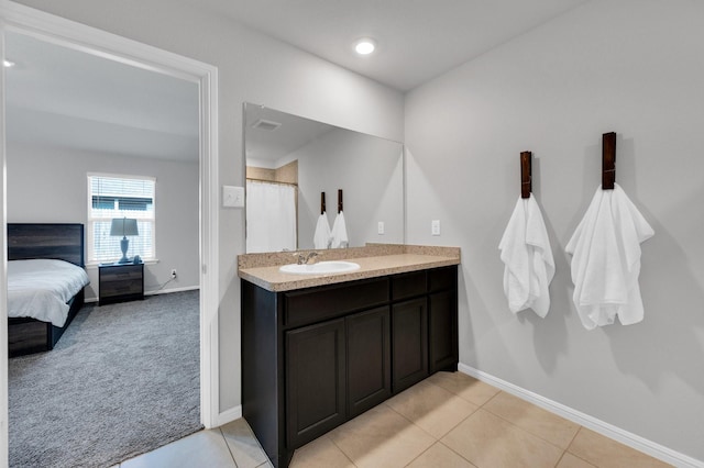ensuite bathroom featuring baseboards, vanity, tile patterned floors, and a shower with shower curtain