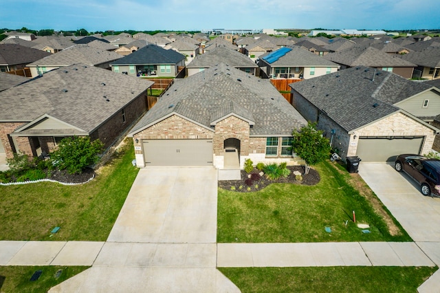 view of front of home featuring concrete driveway, brick siding, a residential view, and an attached garage