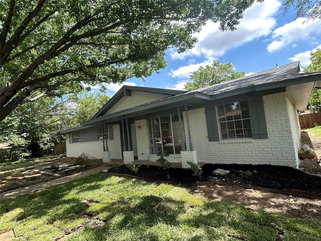 1109 Roman Rd, Grand Prairie, TX 75050 - view of front of home with brick siding, a front lawn, and a porch