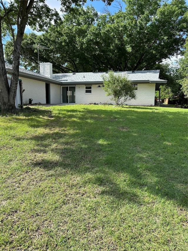1109 Roman Rd, Grand Prairie, TX 75050 - rear view of property with brick siding, a lawn, and a chimney