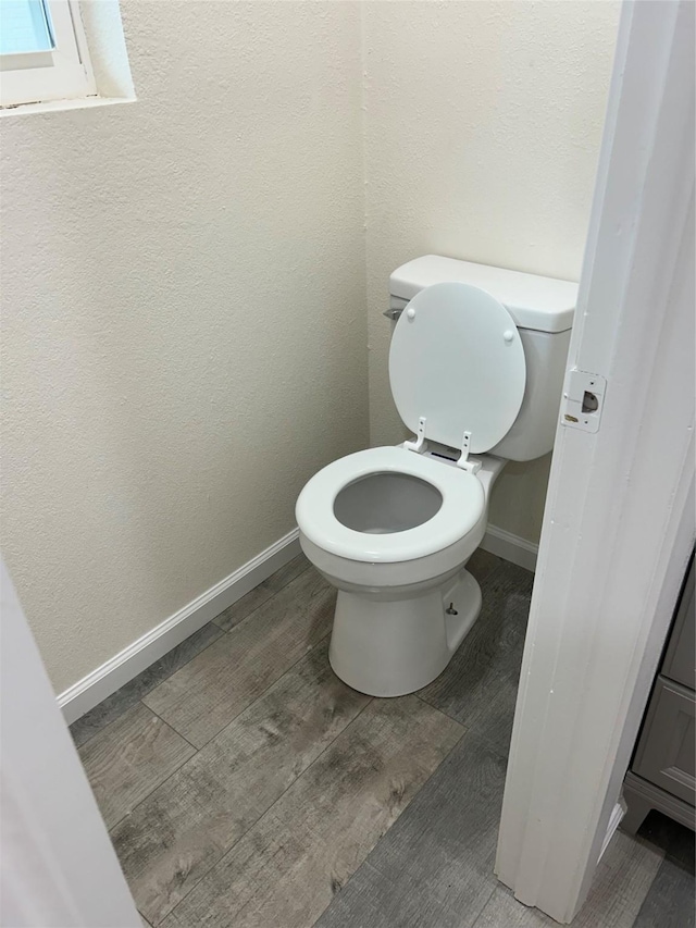 1109 Roman Rd, Grand Prairie, TX 75050 - bathroom with baseboards, toilet, and wood finished floors