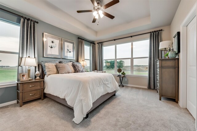 126 Range Ln, Decatur, TX 76234 - bedroom with a tray ceiling, light carpet, baseboards, and ceiling fan