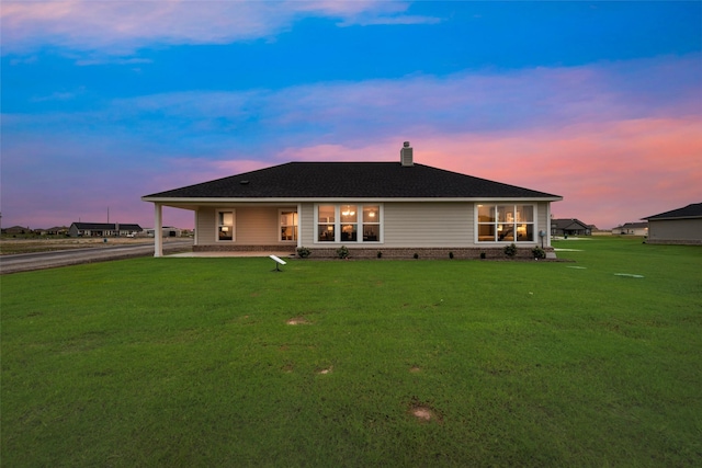 126 Range Ln, Decatur, TX 76234 - back of property at dusk with a chimney, driveway, a yard, and a shingled roof