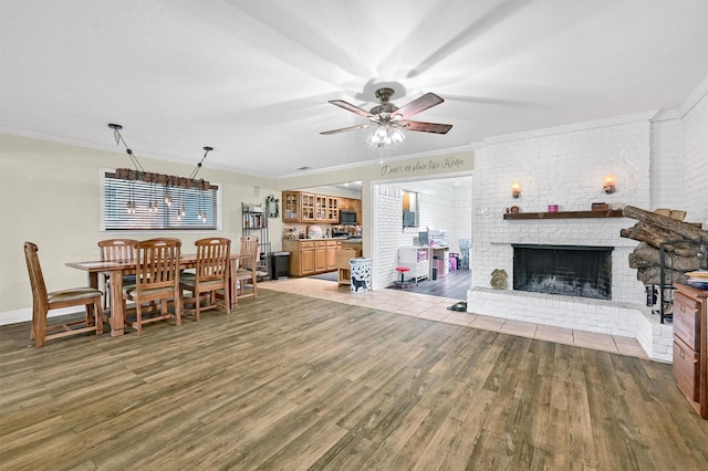 112 S Wood Ave, Denison, TX 75020 - living room featuring crown molding, wood finished floors, a ceiling fan, a fireplace, and brick wall