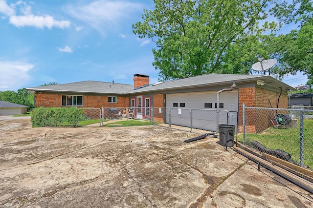 112 S Wood Ave, Denison, TX 75020 - back of house featuring brick siding, a gate, concrete driveway, a garage, and a chimney