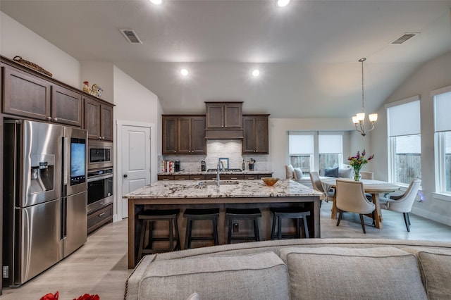 7412 Foxgrass Pl, Fort Worth, TX 76123 - kitchen featuring appliances with stainless steel finishes, lofted ceiling, decorative backsplash, dark brown cabinets, and a chandelier