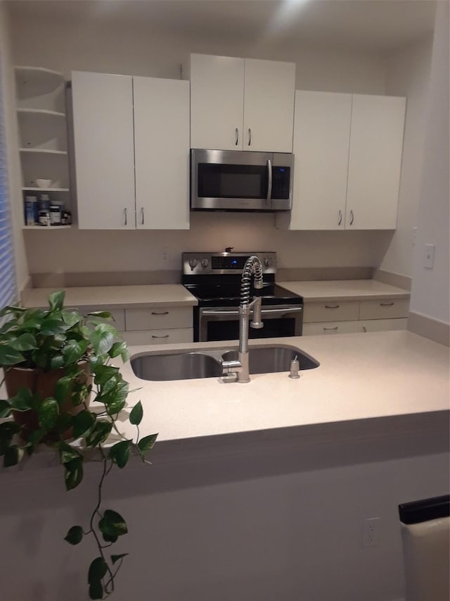 3817 Gilbert Ave Unit 108, Dallas, TX 75219 - kitchen with appliances with stainless steel finishes, light countertops, white cabinetry, and a sink