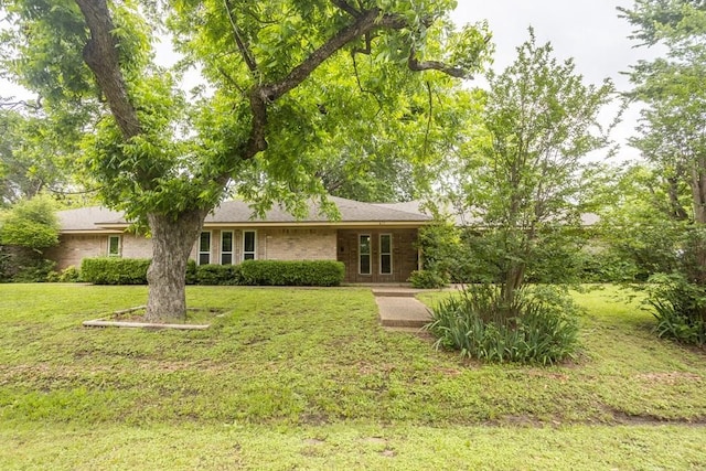 rear view of house with a lawn and brick siding