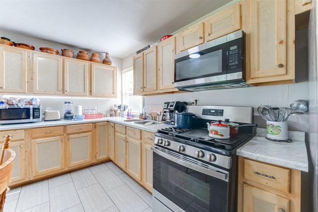 2957 Darby Dr, Dallas, TX 75227 - kitchen featuring appliances with stainless steel finishes, light brown cabinetry, a sink, light countertops, and light tile patterned floors