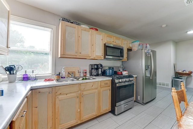 2957 Darby Dr, Dallas, TX 75227 - kitchen with stainless steel appliances, light brown cabinets, a sink, and light countertops