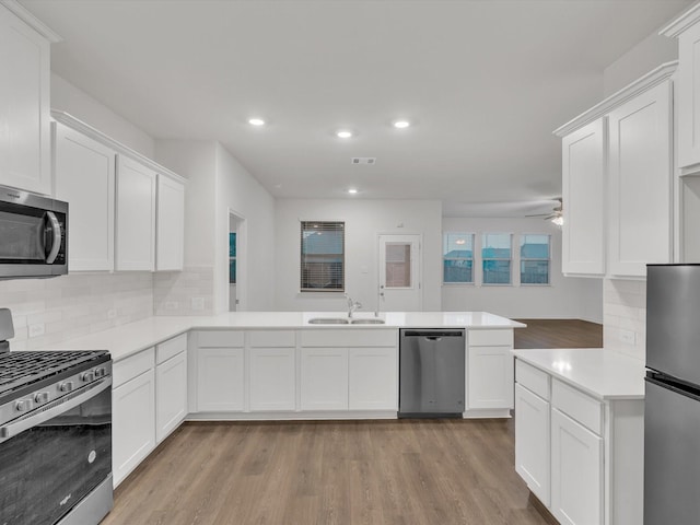1116 Cobalt Dr, Celina, TX 75009 - kitchen with stainless steel appliances, a sink, a peninsula, light wood finished floors, and light countertops