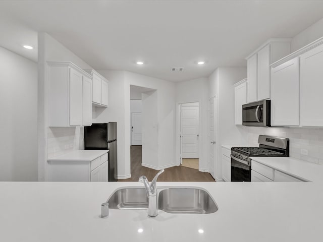 1116 Cobalt Dr, Celina, TX 75009 - kitchen featuring appliances with stainless steel finishes, a sink, light countertops, recessed lighting, and white cabinetry
