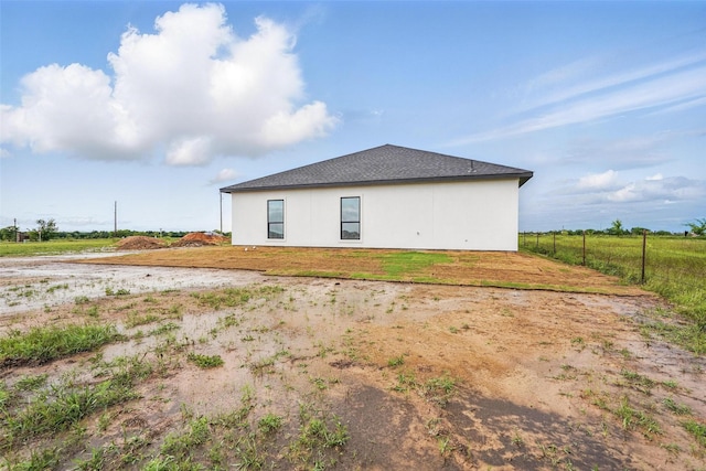 back of property with fence and stucco siding