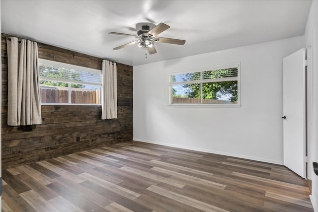 407 Sunset St, Malakoff, TX 75148 - empty room featuring healthy amount of natural light, a ceiling fan, wood finished floors, baseboards, and wood walls