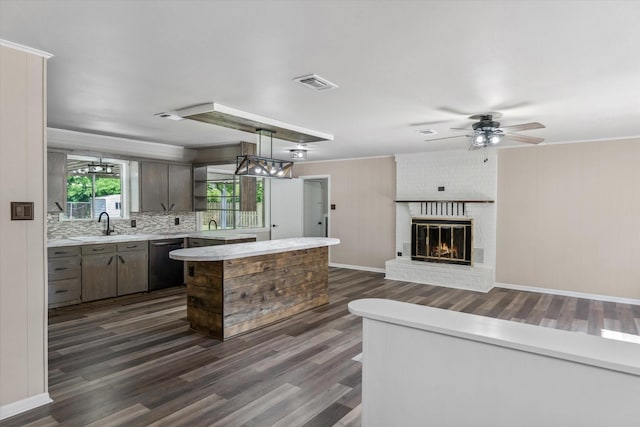 407 Sunset St, Malakoff, TX 75148 - kitchen featuring dishwasher, light countertops, dark wood-style flooring, a fireplace, and ceiling fan
