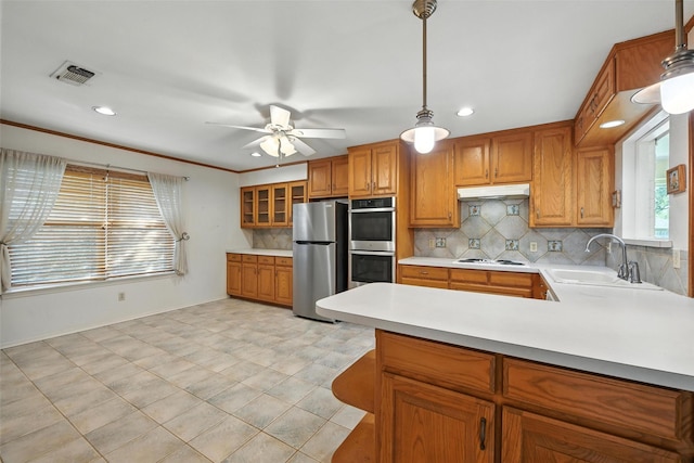 3908 Windhaven Rd, Fort Worth, TX 76133 - kitchen with stainless steel appliances, light countertops, backsplash, brown cabinets, and recessed lighting