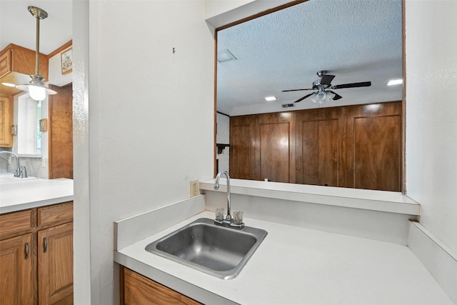 3908 Windhaven Rd, Fort Worth, TX 76133 - kitchen with a ceiling fan, brown cabinets, light countertops, a textured ceiling, and recessed lighting