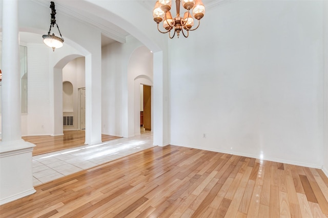 212 Longview Ct, Keller, TX 76248 - spare room featuring light wood-style flooring, arched walkways, a chandelier, and a high ceiling
