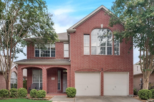 traditional-style home with concrete driveway, brick siding, an attached garage, and covered porch