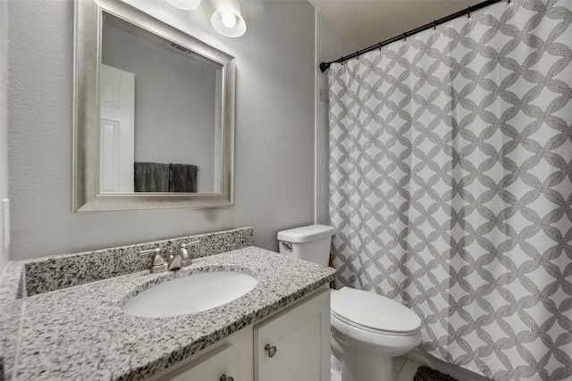 bathroom with toilet, vanity, and a shower with curtain