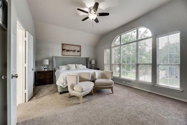 bedroom featuring multiple windows, carpet, vaulted ceiling, and a ceiling fan