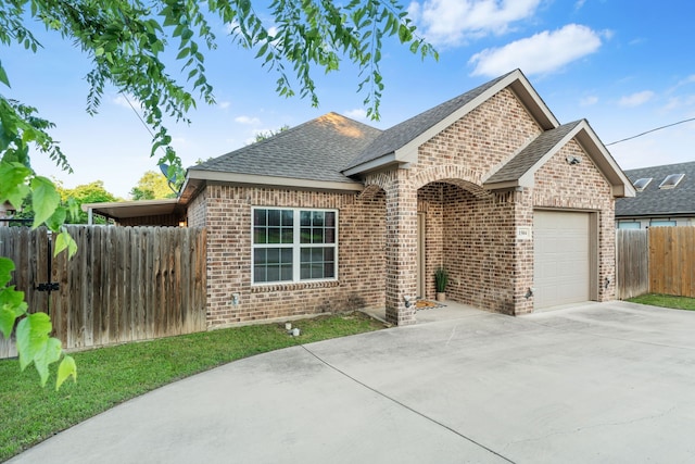 view of front of home with brick siding, concrete driveway, a shingled roof, and an attached garage