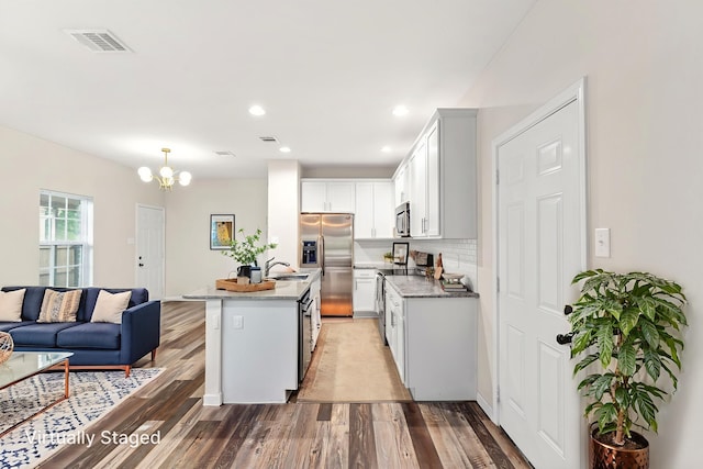 1504 Yale St, River Oaks, TX 76114 - kitchen featuring appliances with stainless steel finishes, a chandelier, light wood-type flooring, open floor plan, and a kitchen island with sink