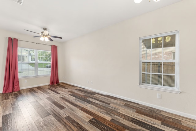 unfurnished room with wood finished floors, baseboards, and a ceiling fan
