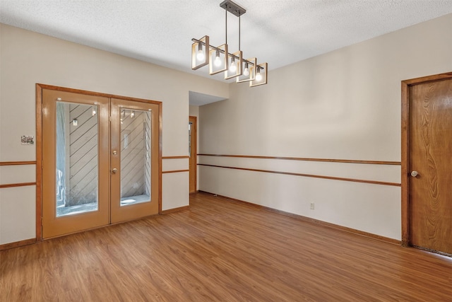 619 Wellington, Tyler, TX 75703 - spare room featuring wood finished floors, baseboards, and a textured ceiling