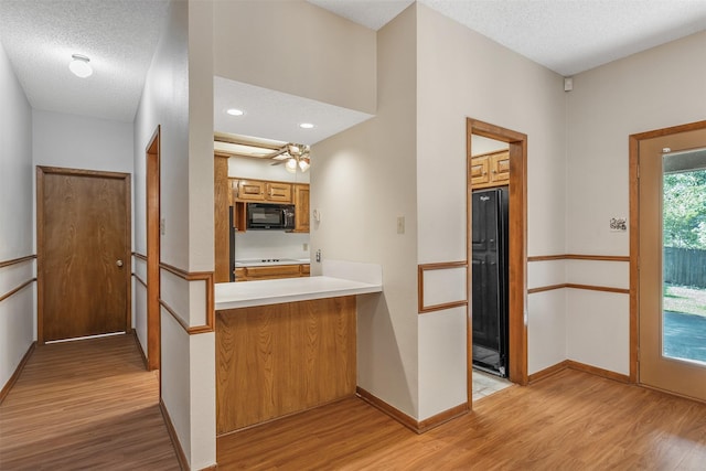 619 Wellington, Tyler, TX 75703 - kitchen featuring black appliances, light wood-type flooring, baseboards, light countertops, and brown cabinetry