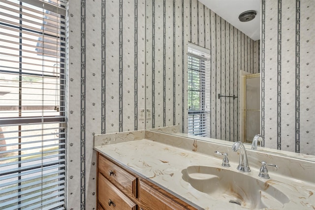 619 Wellington, Tyler, TX 75703 - bathroom featuring vanity, wallpapered walls, and a shower with door