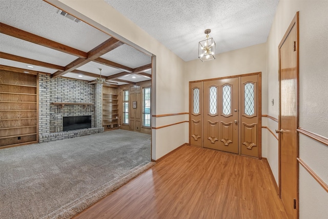 619 Wellington, Tyler, TX 75703 - entrance foyer featuring a textured ceiling, a fireplace, light wood-style flooring, beam ceiling, and a chandelier