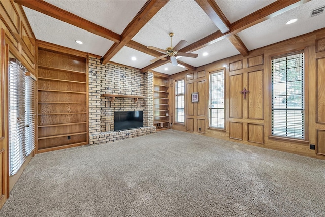 619 Wellington, Tyler, TX 75703 - unfurnished living room with a textured ceiling, beam ceiling, a ceiling fan, built in features, and carpet floors