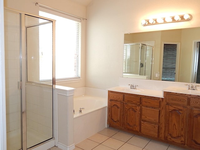 bathroom with a shower stall, a bath, double vanity, and tile patterned floors