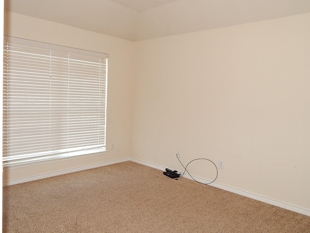 empty room featuring carpet and baseboards
