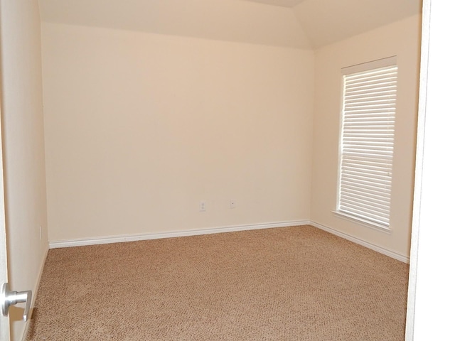 unfurnished room with carpet flooring, vaulted ceiling, and baseboards