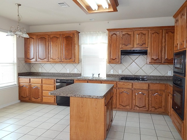 kitchen with black appliances, a sink, light tile patterned flooring, and brown cabinetry