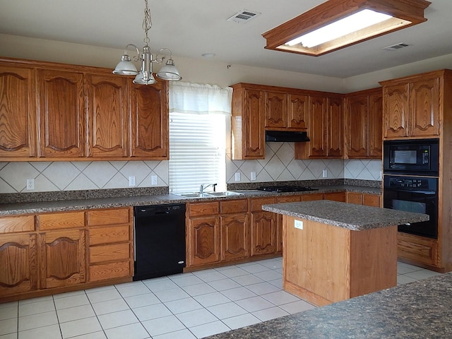 kitchen featuring black appliances, under cabinet range hood, brown cabinetry, a sink, and backsplash