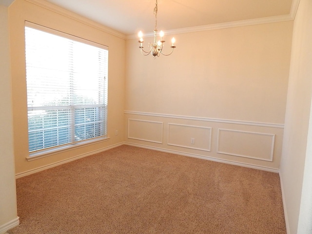 carpeted spare room with a chandelier, crown molding, and wainscoting