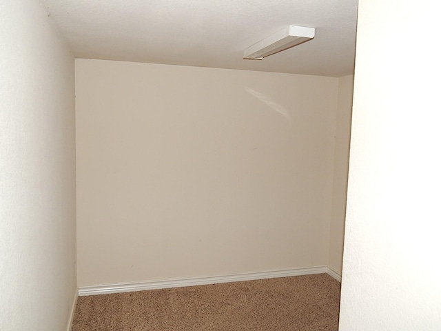 carpeted empty room featuring baseboards