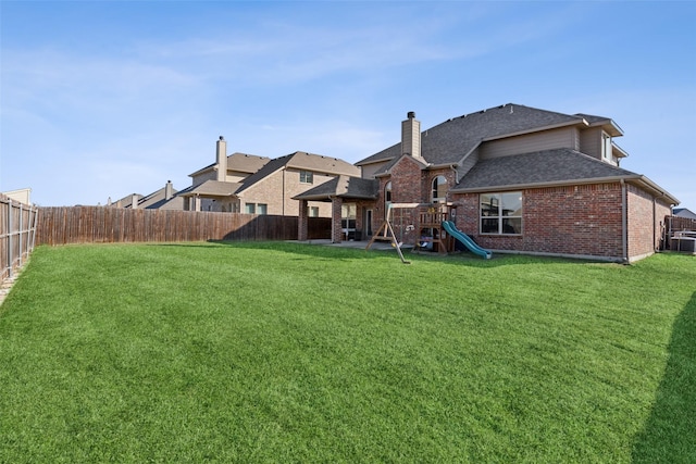 2002 Trinity Ln, Wylie, TX 75098 - rear view of property with a playground, brick siding, a shingled roof, and a chimney