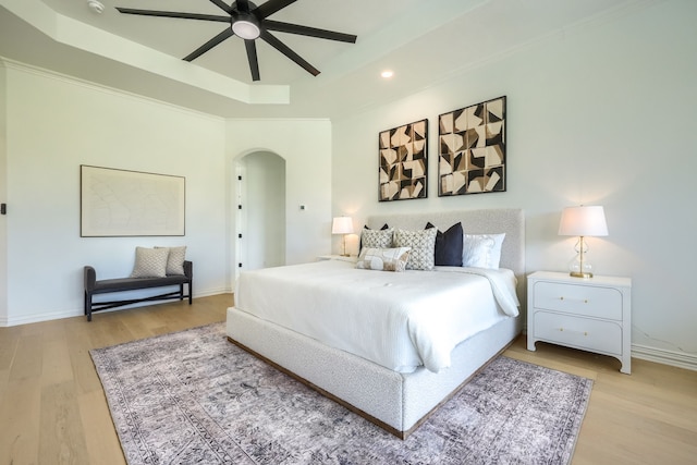 12809 Day Break Trl, Burleson, TX 76028 - bedroom with arched walkways, a tray ceiling, light wood finished floors, baseboards, and recessed lighting
