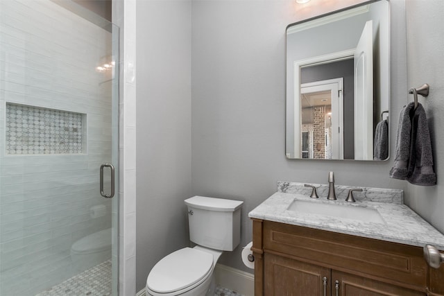 full bath with a shower stall, toilet, vanity, and baseboards